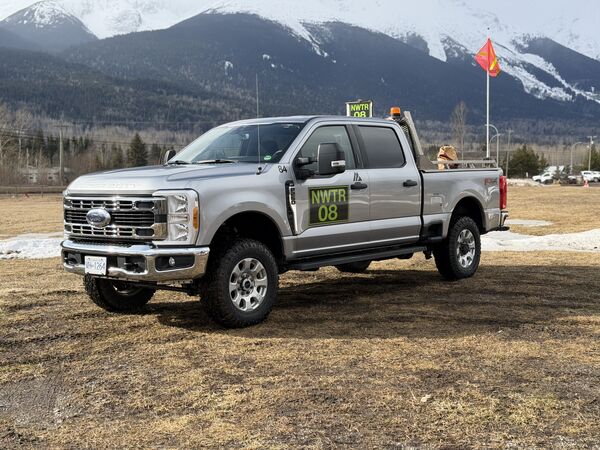 Silver Northwest Truck Rentals worksite-ready pickup with fluorescent green unit decal and buggy whip